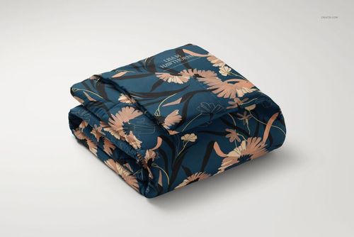 Microfiber comforter mockup featuring a folded blanket with peach and beige flowers on a navy blue surface.