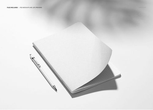 Stationery notebook mockup shown in a top view, featuring a lifted cover and a pen placed beside it.