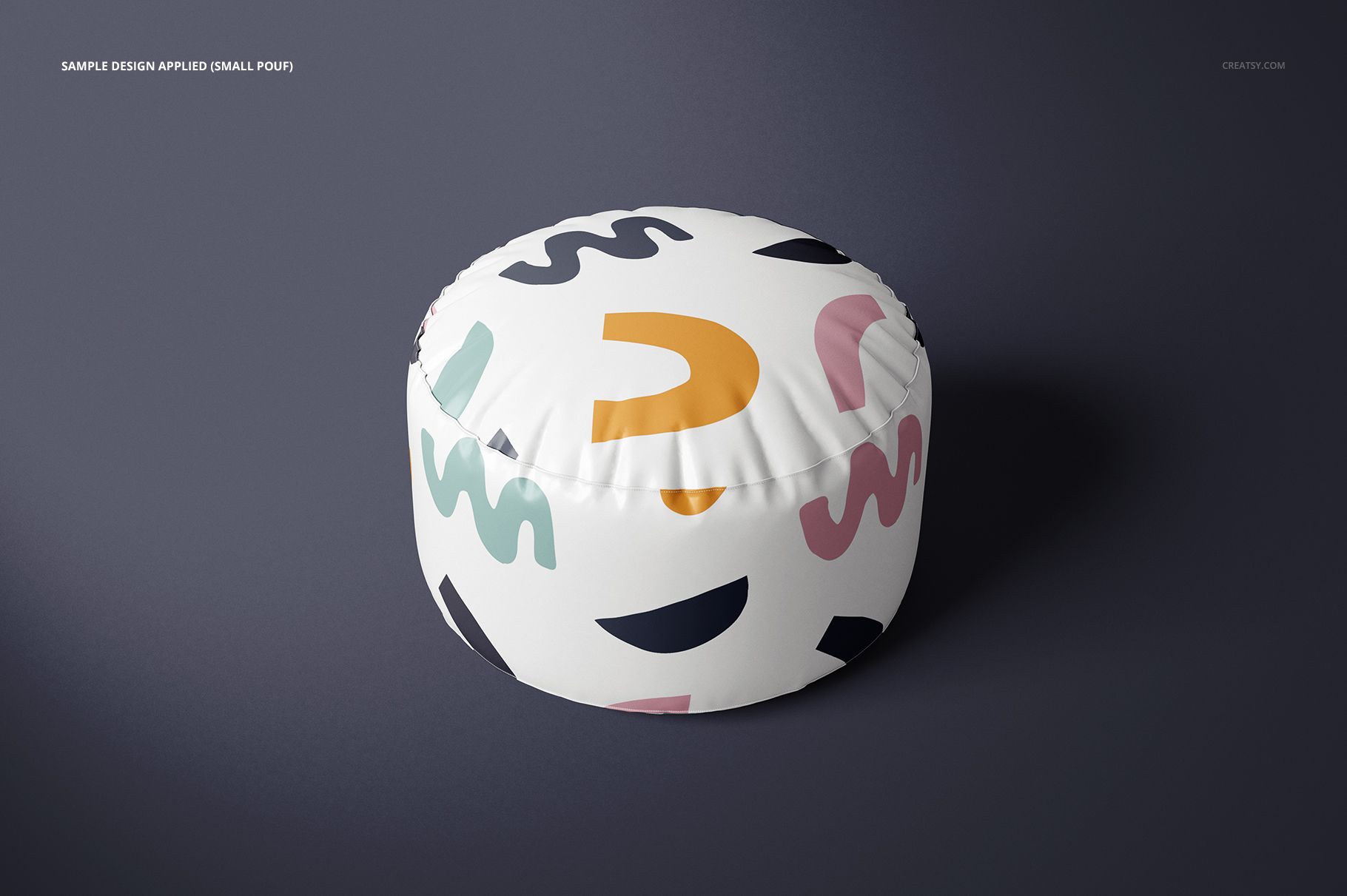 Small round pouf mockup with multicolored abstract pattern, displayed on a plain dark surface with soft shadow.