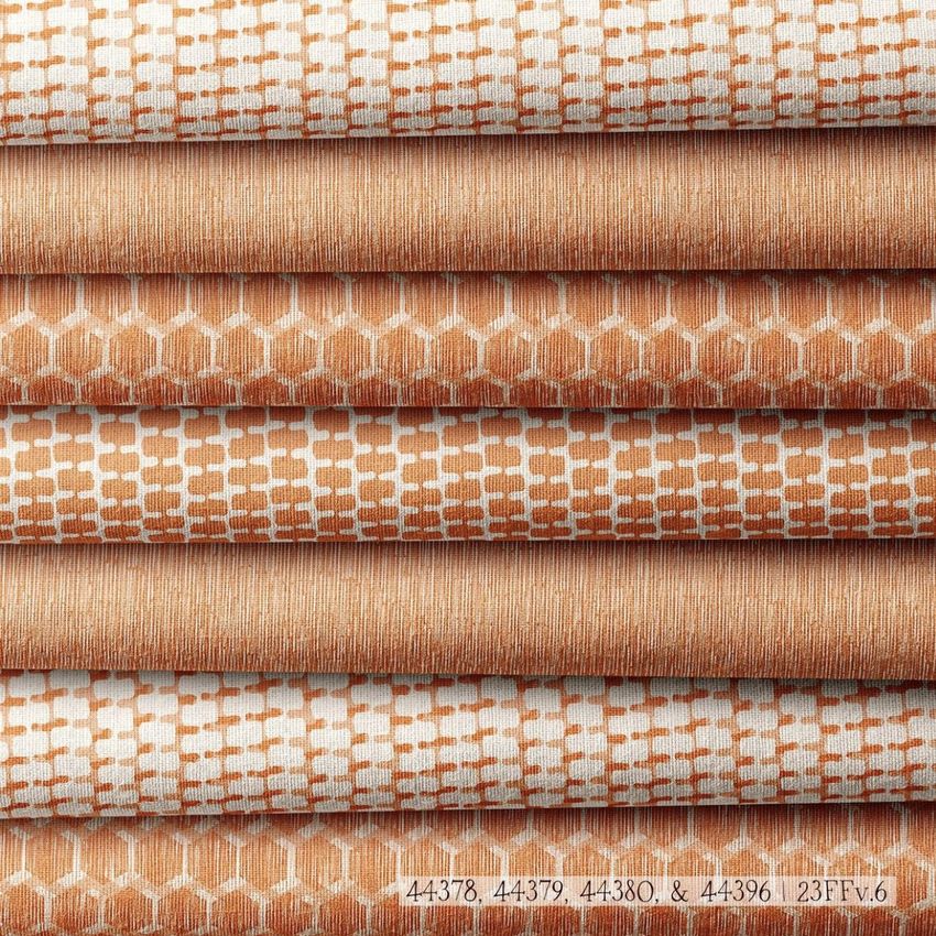 Fabric stack mockup showing several folded textiles with geometric orange and white patterns arranged in a neat pile.