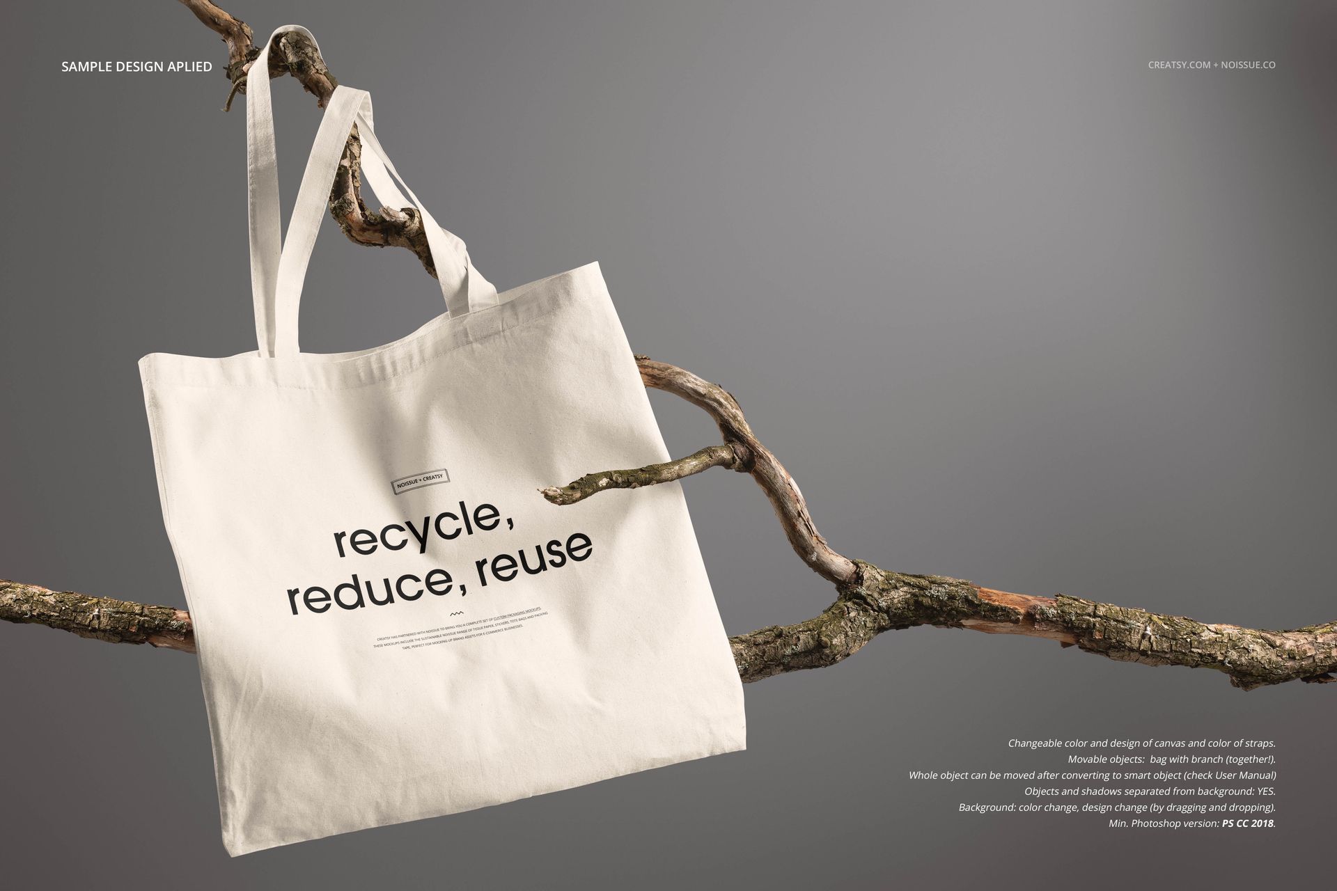 Front view of a natural canvas tote bag mockup hanging on a branch, featuring black printed text and neutral background.