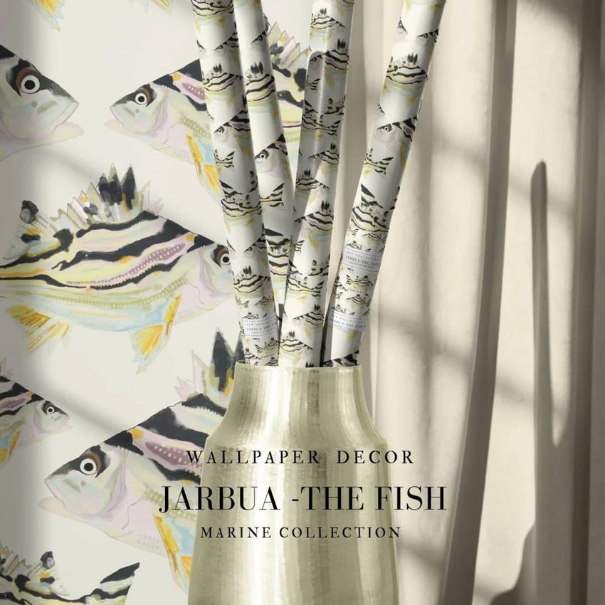 Wrapping paper rolls with fish illustrations arranged in a metallic vase, set against a matching fish-patterned wallpaper.
