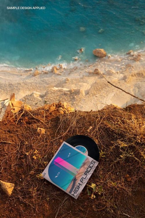 PSD mockup showing a vinyl record and sleeve on earthy terrain with a dramatic view of the beach and sea below.