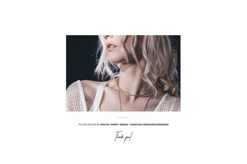 Poster mockup displayed against a wooden backdrop near a store entrance, featuring a close-up of a person with light hair and layered necklaces.