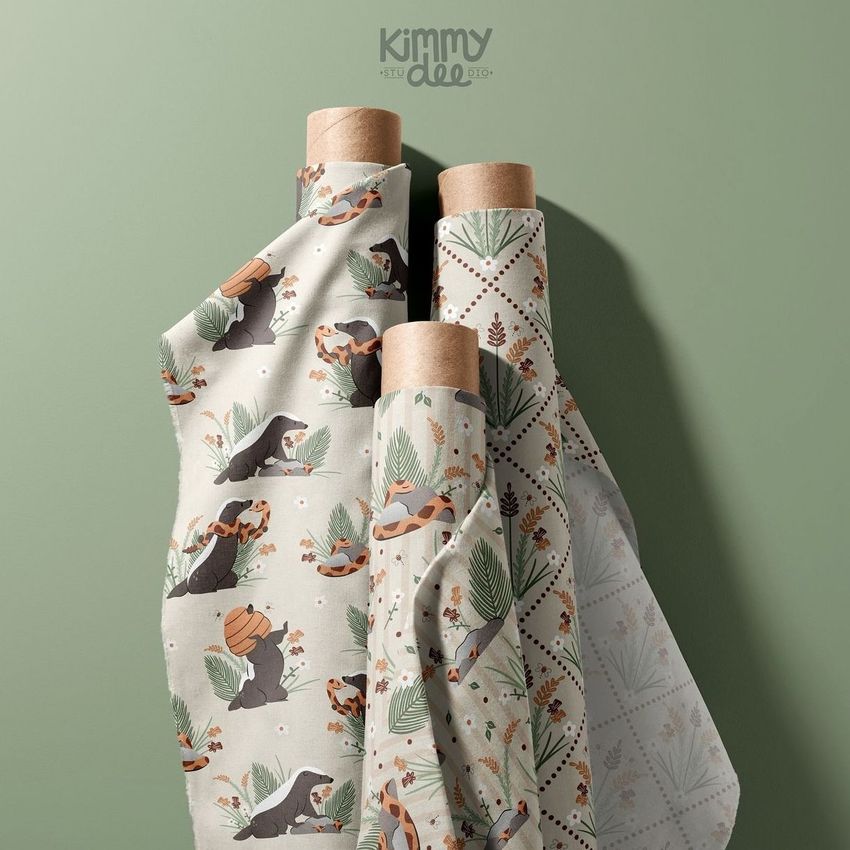 Fabric rolls mockup featuring three upright rolls with illustrated animal and botanical patterns against a muted green background.