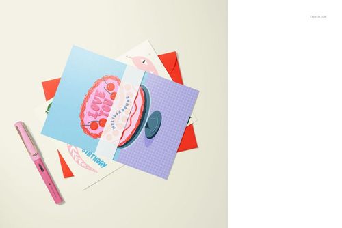 A5 cards mockup featuring several greeting cards with vibrant artwork, arranged with a pink pen on a pale background.