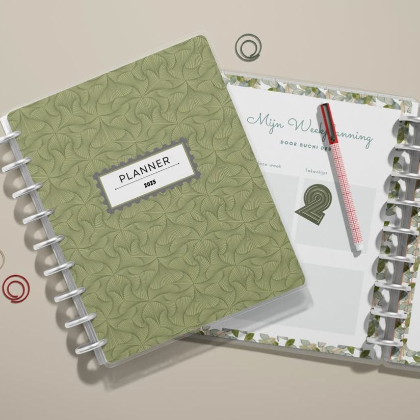 Two spiral notebook mockups seen from above, with decorative paper clips and a red pen placed on an open planner page.