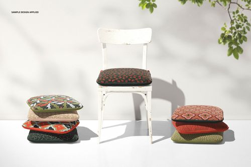 Stacked patterned chair cushions in various colors next to a rustic white chair with a cushion, shown in a mockup scene.