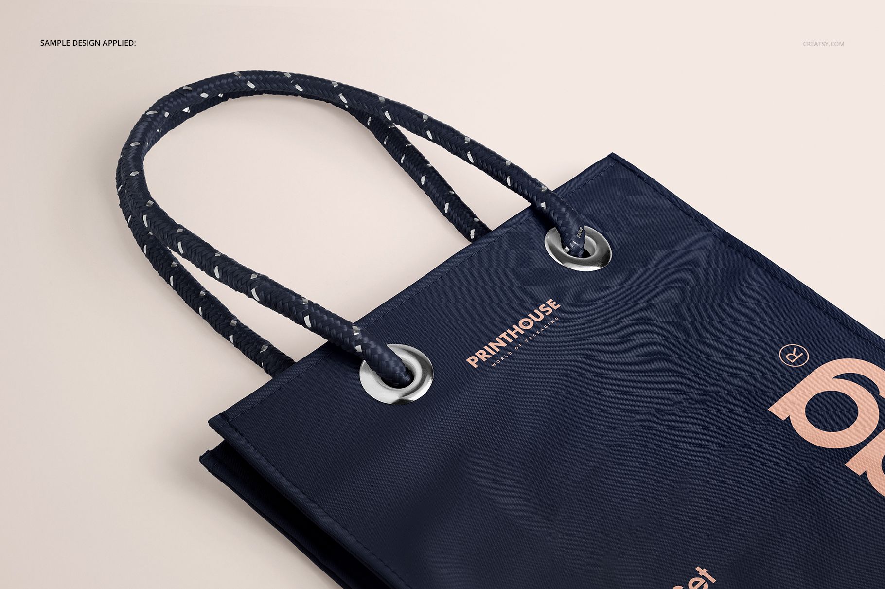 Matte PVC reusable tote bag mockup shown in close-up, featuring navy blue color and rope handles on a neutral background.