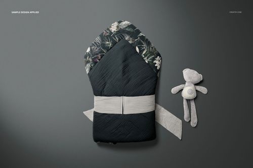 Top view of a muslin baby wrap mockup featuring a dark exterior, floral pattern inside, and a light belt accent.