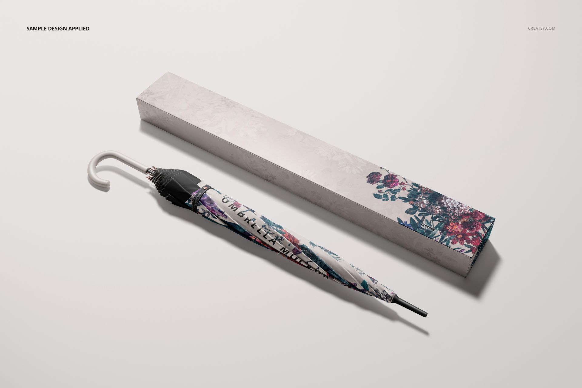PSD mockup featuring a fashion accessory umbrella with colorful flower motifs and a matching packaging box in a minimal scene.