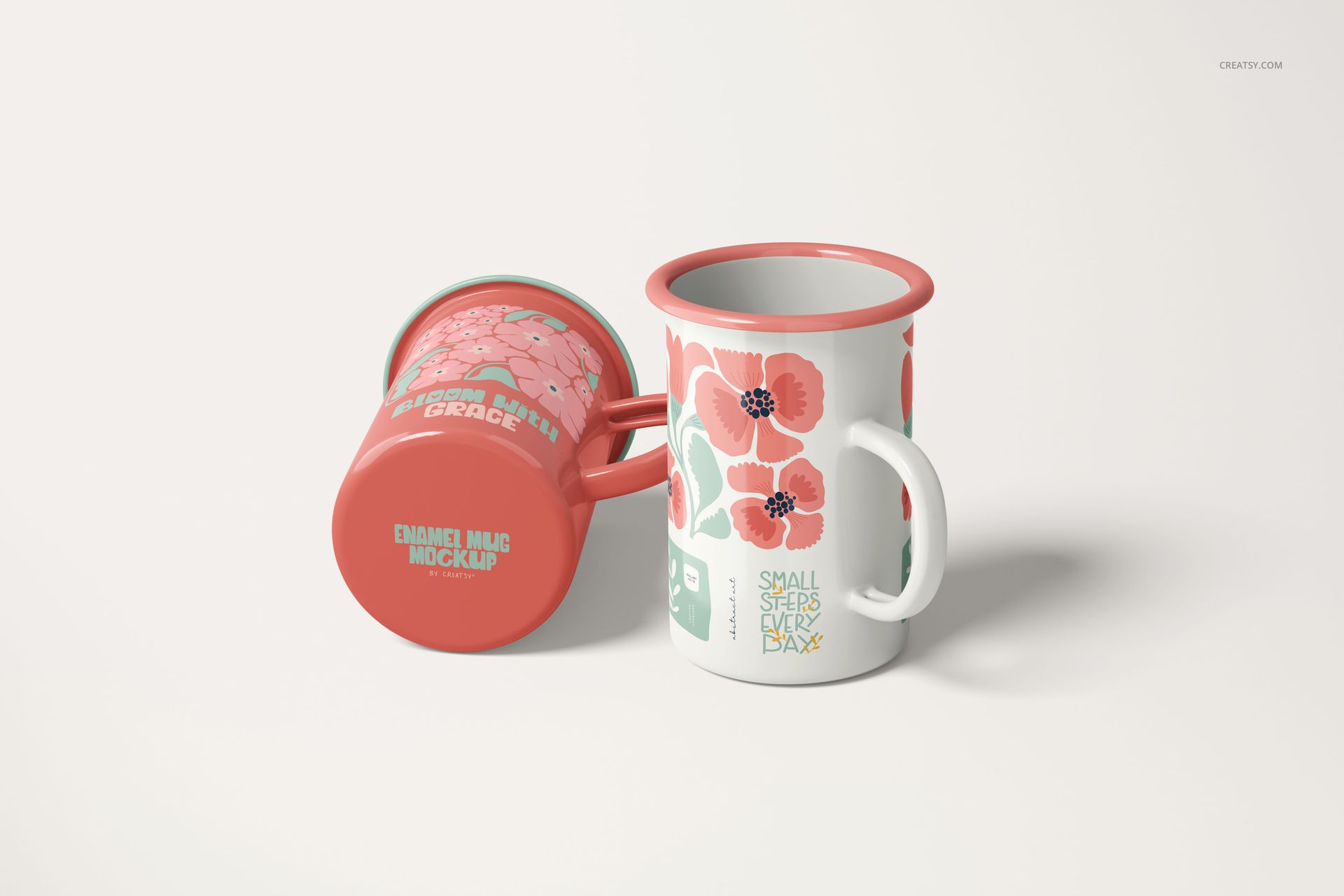 Two enamel mugs with coral rims and handles, featuring pink floral designs, shown on a light surface in a PSD mockup.