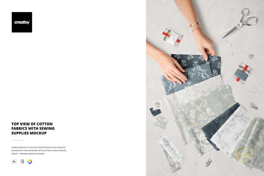 Cotton fabric mockup with sewing items, showing hands organizing patterned textiles and supplies from a top perspective.