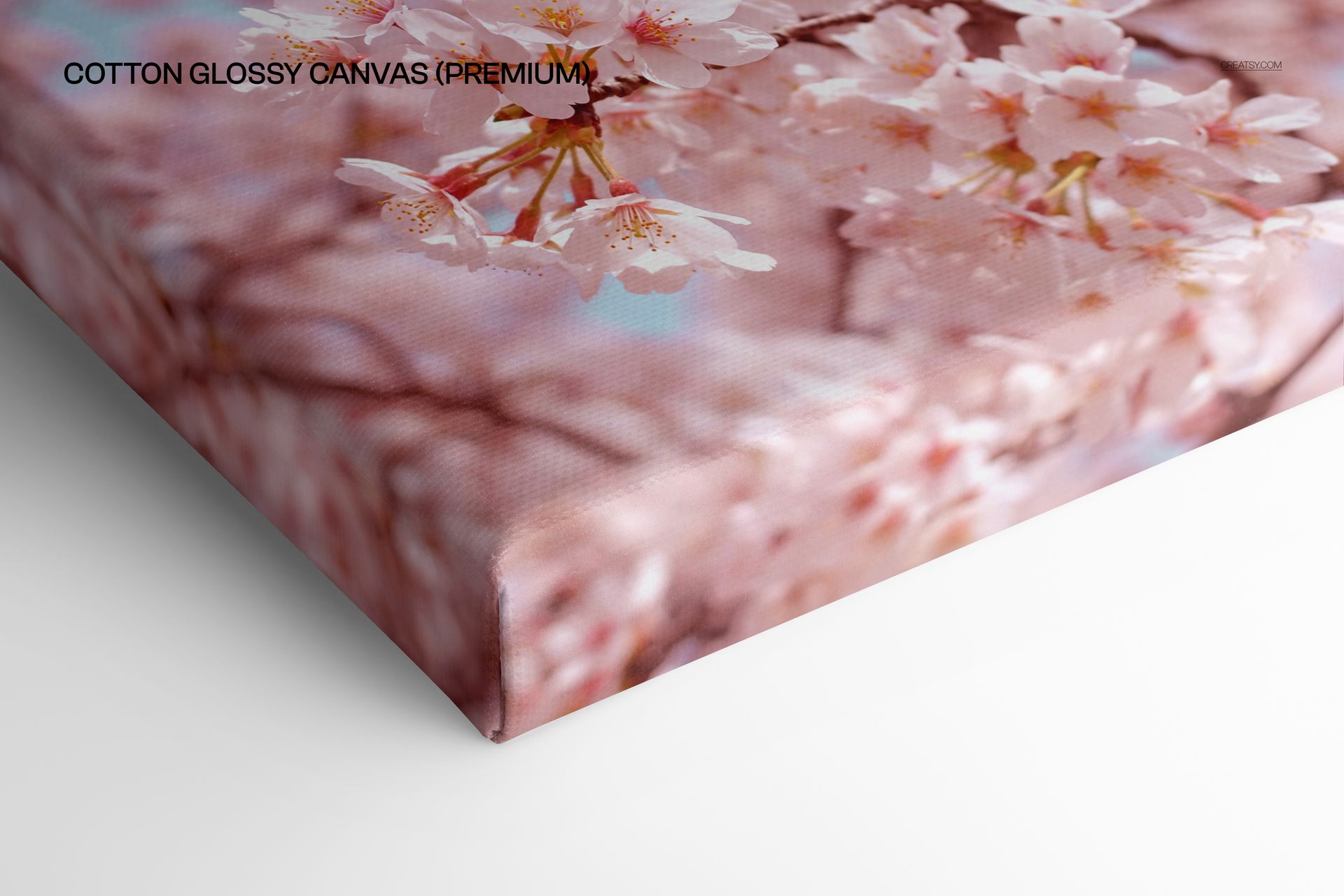Close-up view of a cotton glossy canvas print mockup featuring pink cherry blossom flowers on a white background.