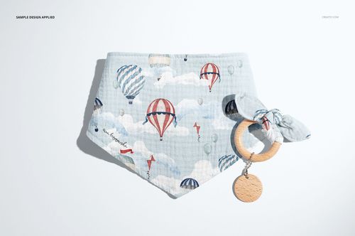 Front view of a baby muslin bandana mockup featuring a playful balloon and cloud print, paired with a wooden teether.