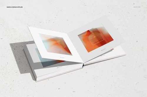 Open artbook mockup displaying two pages with abstract orange artwork, set on a light textured surface.