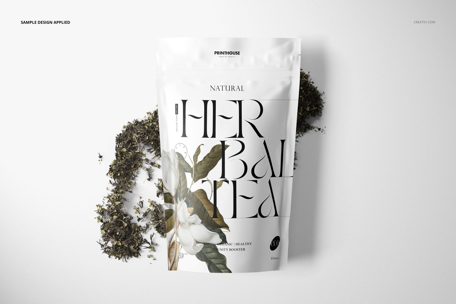Stand up zip lock bag mockup featuring a white background, floral artwork, and scattered tea leaves around the packaging.