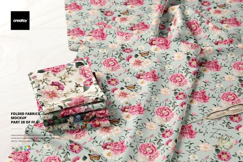 Stacked and unfolded fabric sections featuring pink flowers and butterflies on a light blue background, PSD mockup scene.