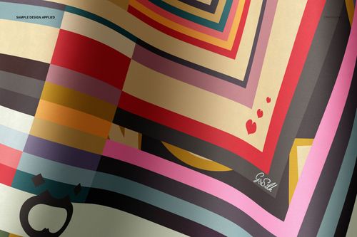 Close-up of a twill silk scarf mockup with vibrant diagonal stripes, small hearts, and abstract shapes on smooth fabric.