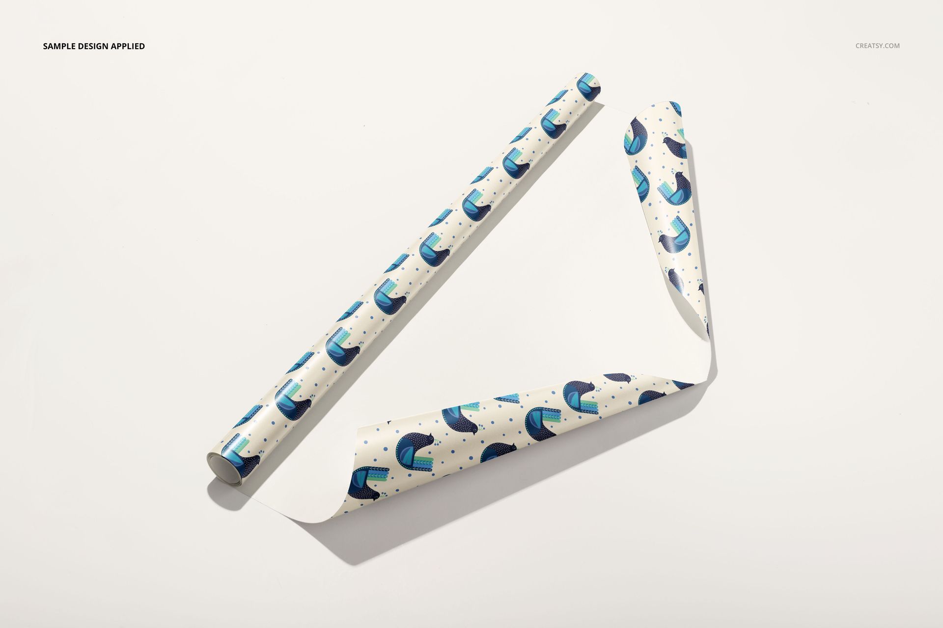 Gift wrapping paper mockup showing two sheets with blue and teal abstract patterns on a light background, top view.