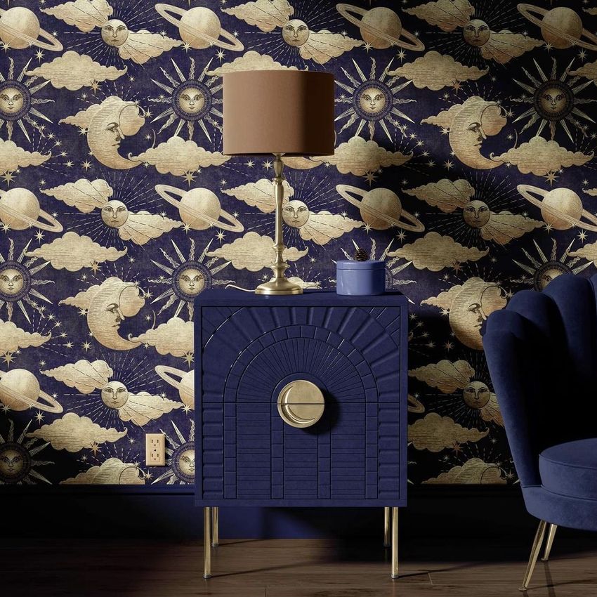 Drum lamp shade mockup with a solid brown shade on a metallic base, placed on a dark blue cabinet against a celestial patterned wallpaper.