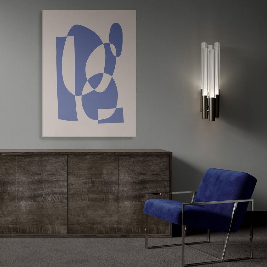 Modern armchair mockup scene with a blue velvet chair, dark wood sideboard, and abstract artwork on a gray wall.