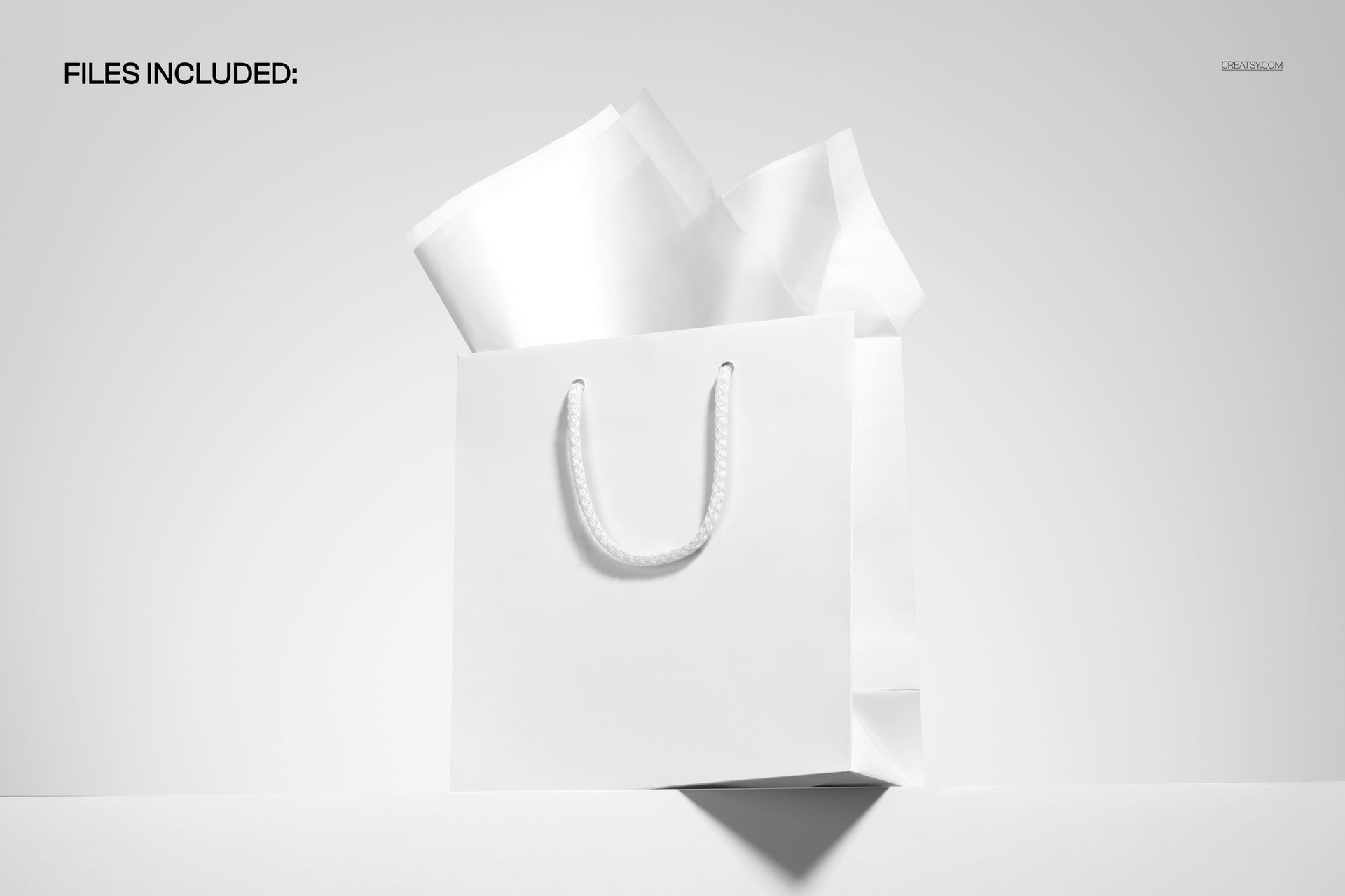 PSD mockup of a plain shopping bag with white rope handles and crumpled tissue paper, placed on a white ledge.
