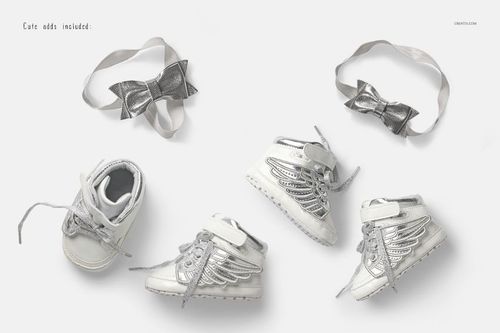 Kids footwear mockup featuring shiny silver sneakers with wing accents and matching silver bows.