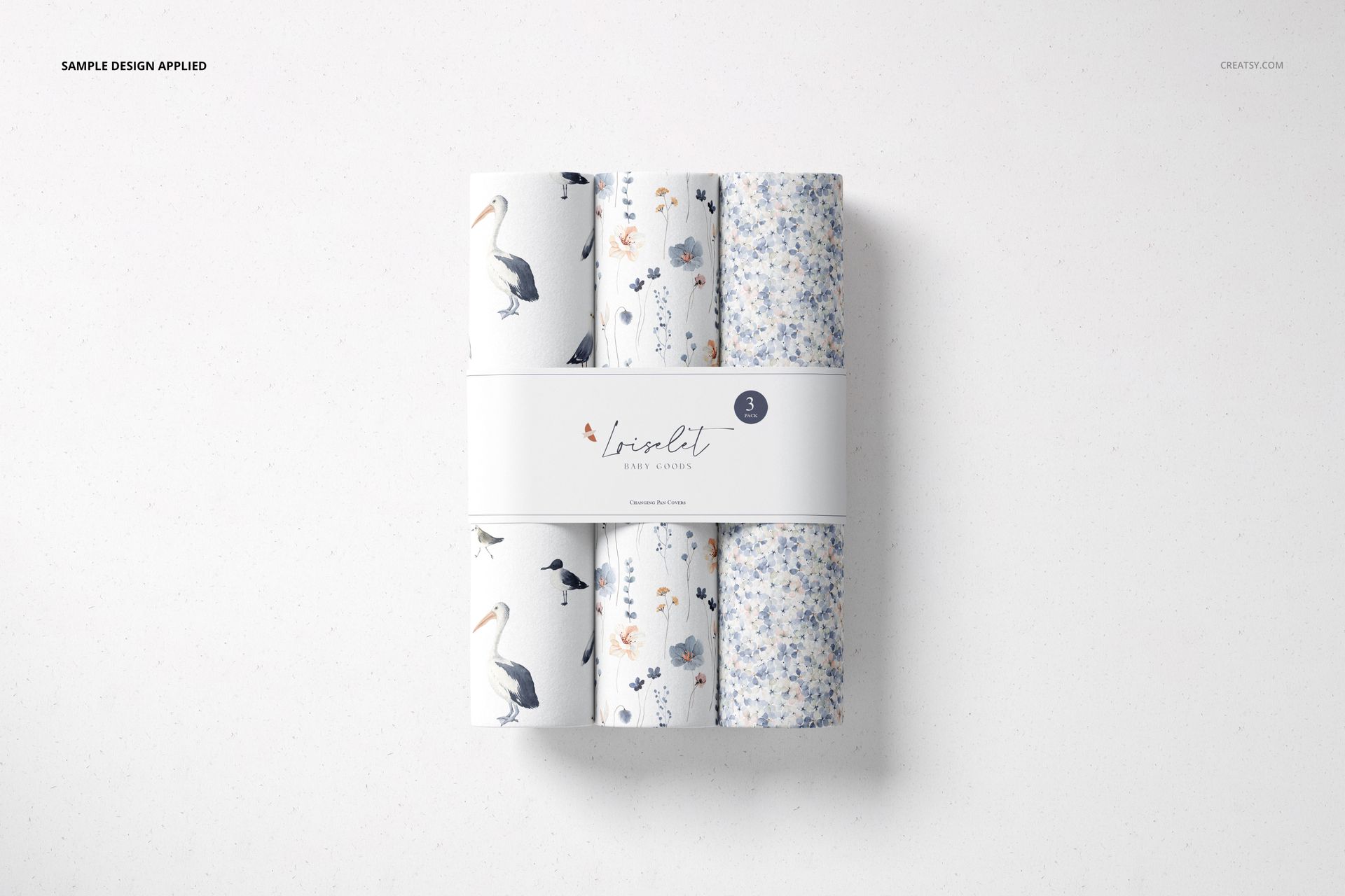 Top view of a changing pad mockup set with four rolled pads featuring blue and white floral and bird patterns.