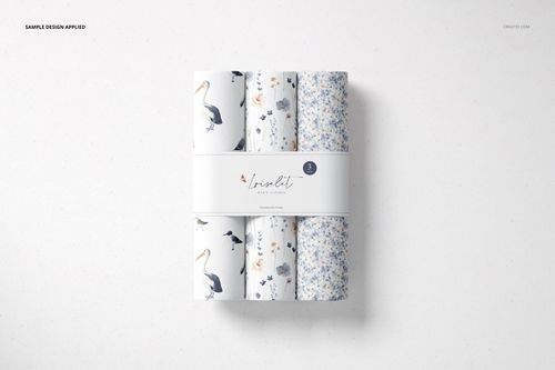 Top view of a changing pad mockup set with four rolled pads featuring blue and white floral and bird patterns.