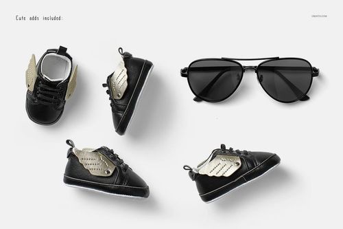 Baby footwear mockup with black sneakers and metallic gold wings, presented with sunglasses on a clean white surface.