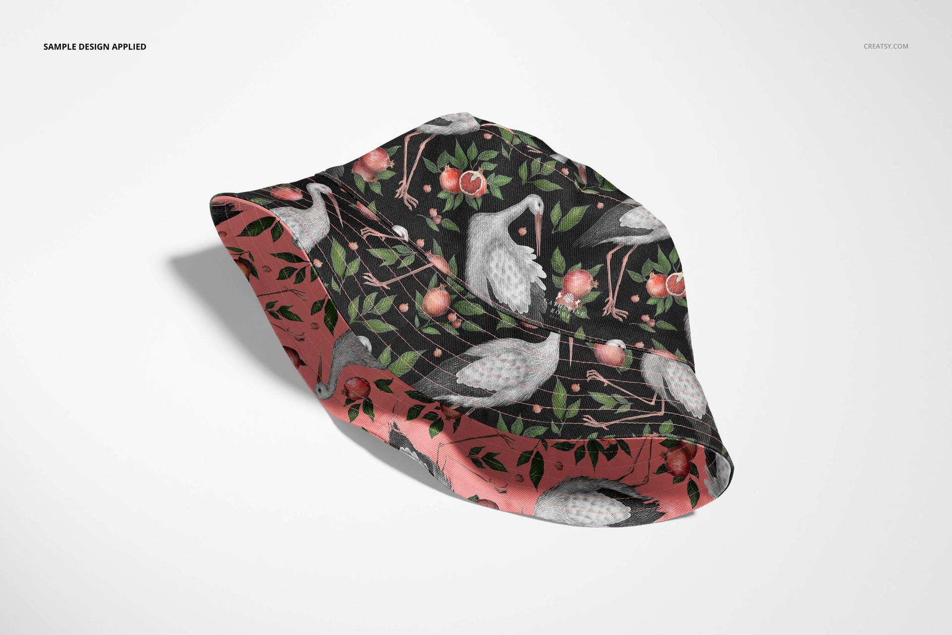 Adult bucket hat mockup featuring a dark side with birds and flowers, displayed at an angle on a white surface.