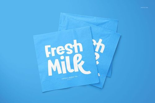 PSD mockup of two square blue napkins featuring large white lettering, arranged on a plain blue surface.