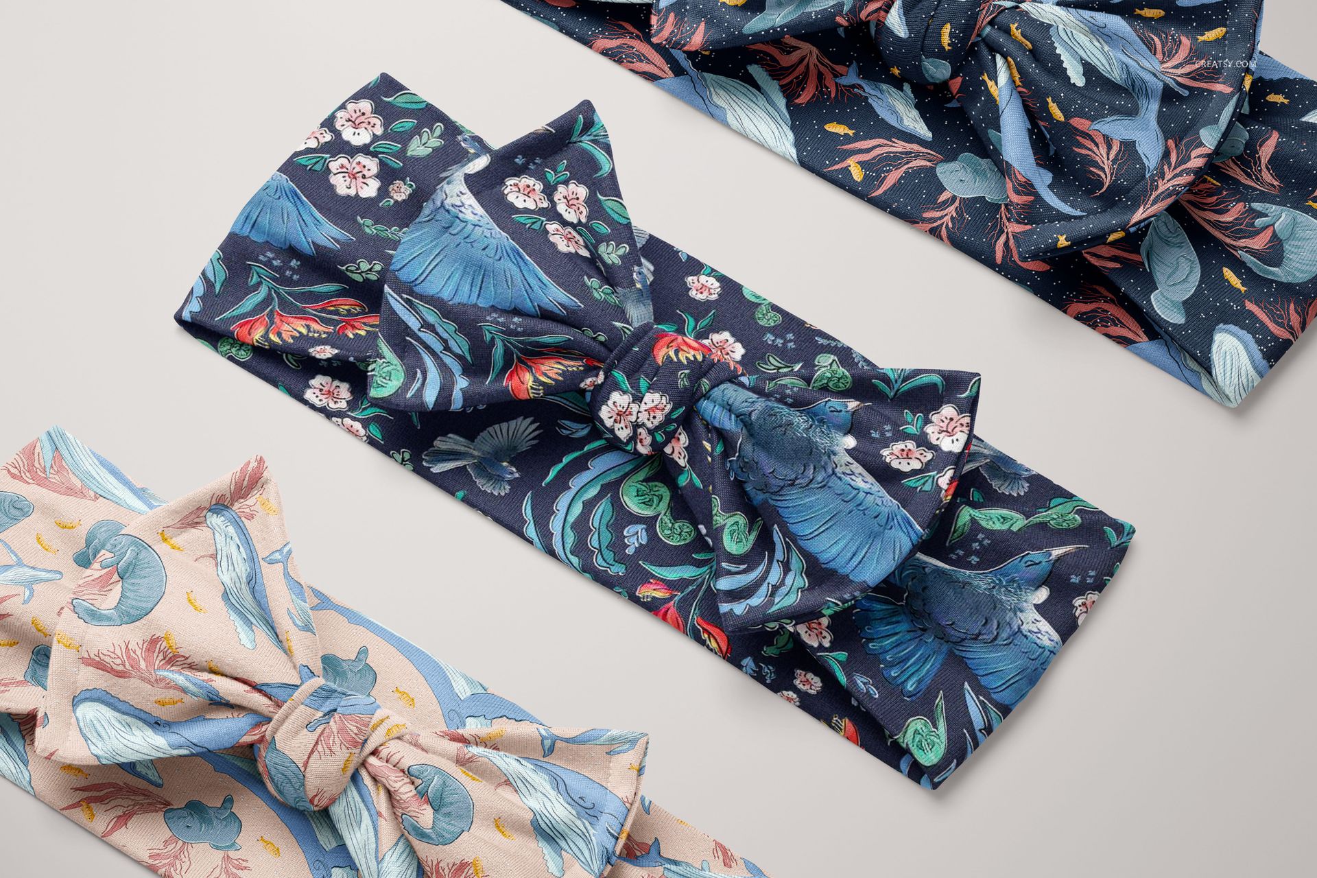 PSD mockup showing three patterned kids headbands with bow ties, featuring nature-inspired prints on a neutral background.