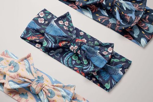 PSD mockup showing three patterned kids headbands with bow ties, featuring nature-inspired prints on a neutral background.