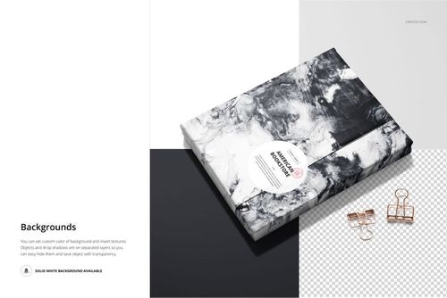 PSD mockup of a book covered in abstract black and white wrapping paper, viewed from above with desk accessories.