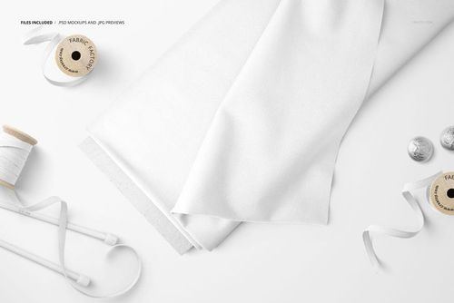 White fabric bolt and ribbons displayed with spools and buttons, shown from a top-down perspective in a mockup scene.