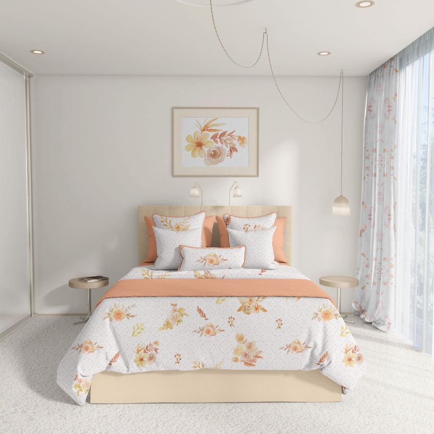 Bedroom scene bedding mockup showing a neatly made bed with floral patterned linens in soft orange and cream tones, framed artwork above, and sheer curtains.
