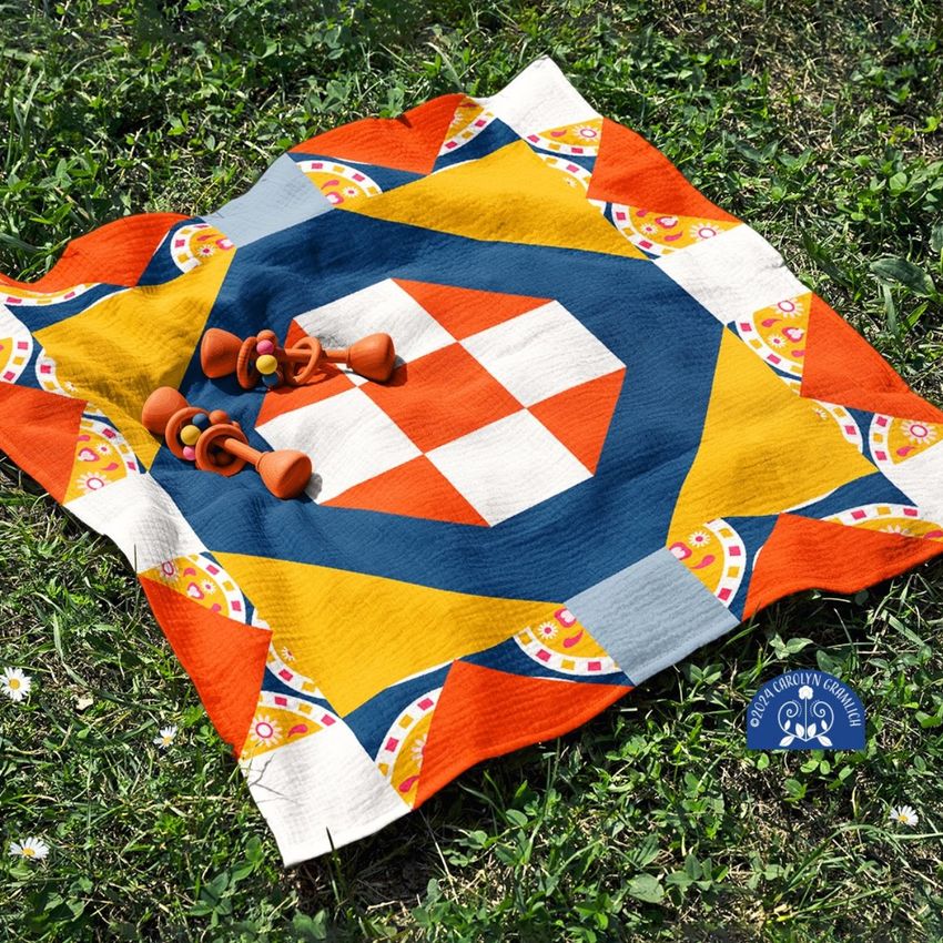 Crinkle cotton muslin swaddle blanket mockup with a bold geometric pattern in orange, blue, and yellow on grass.