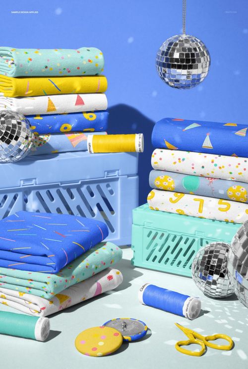 PSD mockup showing assorted jersey fabric stacks with vibrant patterns, surrounded by crates, disco balls, and sewing tools.