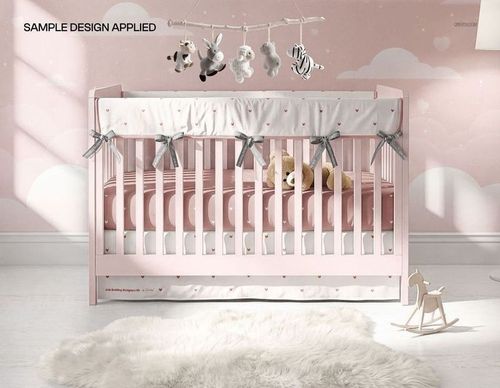 Front view of a nursery crib with a pink crib skirt and rail cover, plush toys, and decorative mobile in a mockup scene.