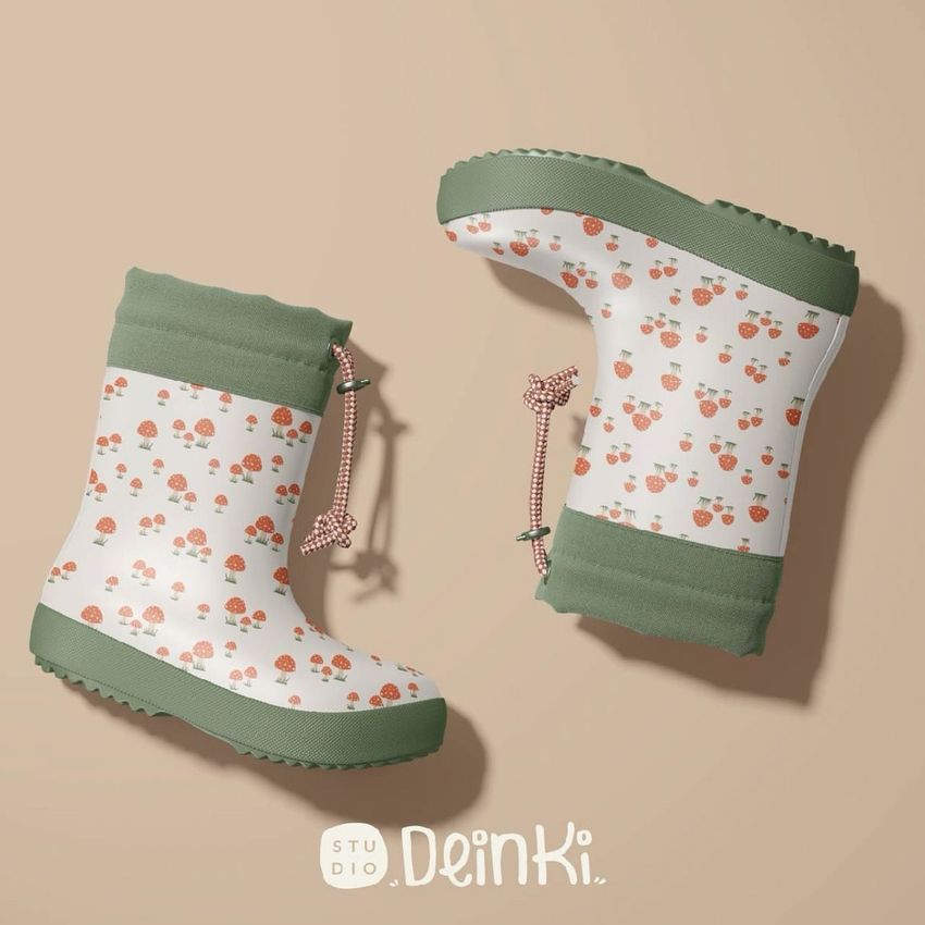 Kids rain boots mockup featuring two boots with green soles and whimsical mushroom patterns on a beige background.