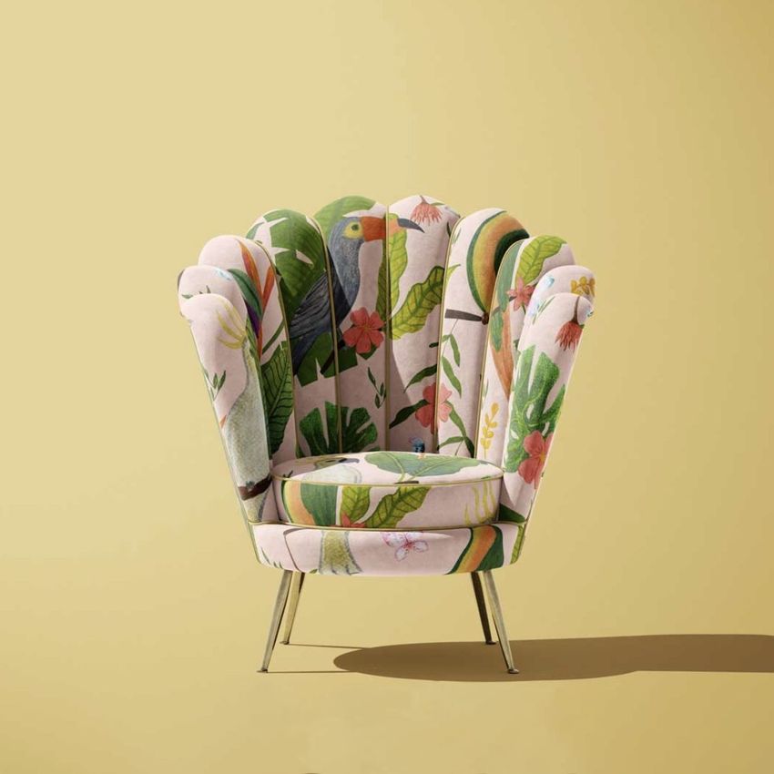 Velvet shell armchair mockup with a botanical pattern featuring birds and leaves, set against a solid light yellow background.
