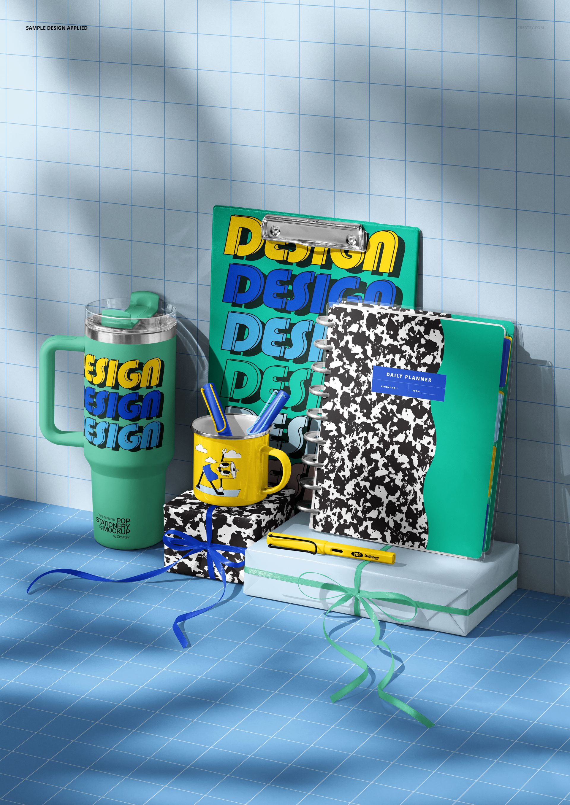 Top view of a PSD mockup featuring assorted desk stationery, including a clipboard, notebooks, and drinkware on a blue grid background.