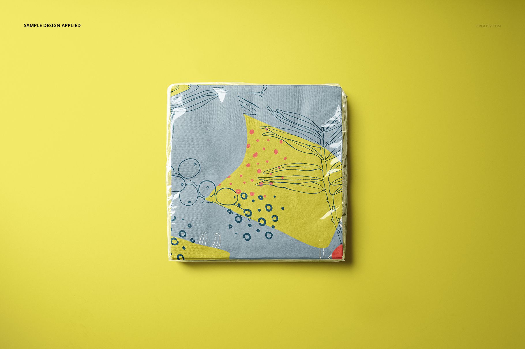 Paper napkins mockup featuring a folded stack with colorful abstract design, displayed against a yellow backdrop.