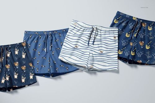 Front view of a PSD mockup set showing kids swim shorts with various aquatic and animal prints in blue and white colors.