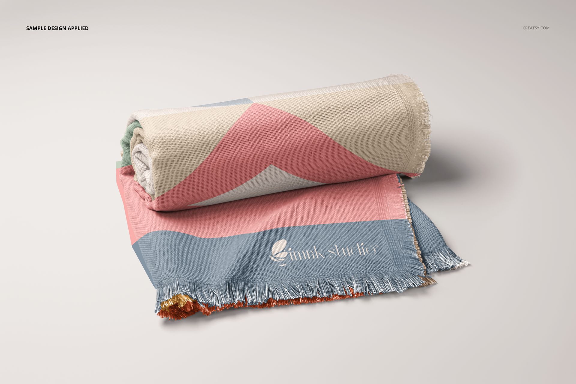 Front view of a polyester woven blanket mockup with geometric pastel pattern, rolled and folded on a light surface.