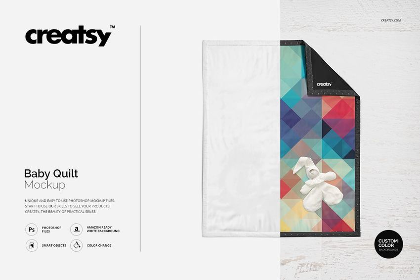 Top view of a baby quilt mockup with a geometric multicolor pattern and a plush toy on a wooden surface.