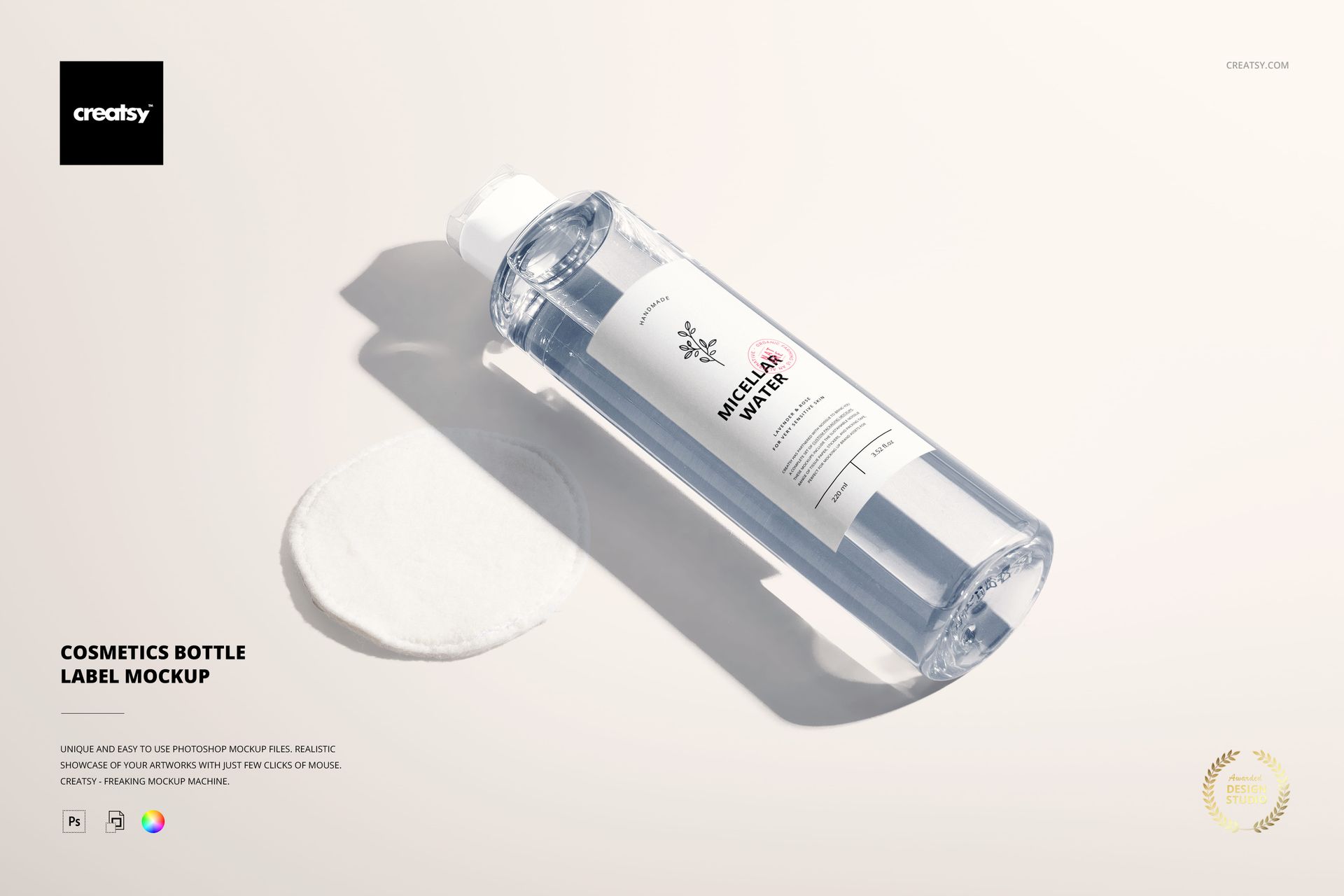 PSD mockup of a transparent cosmetics bottle with a white label, displayed on a soft light surface next to a cotton pad.