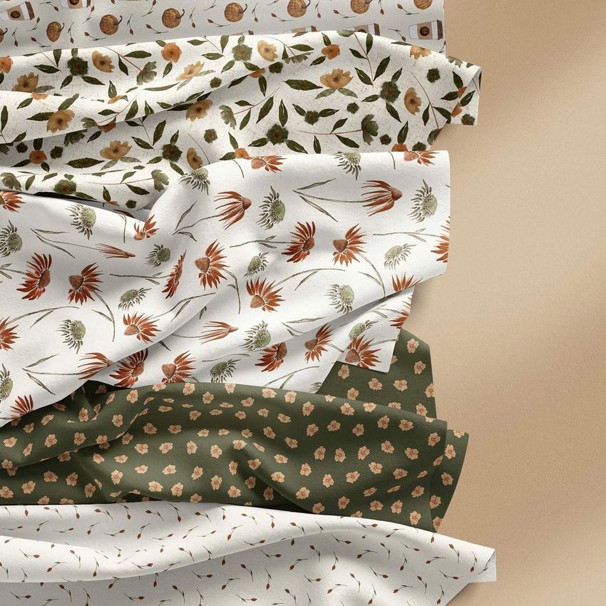Creased fabrics mockup displaying five fabric pieces with autumn floral patterns in earthy tones on a neutral background.